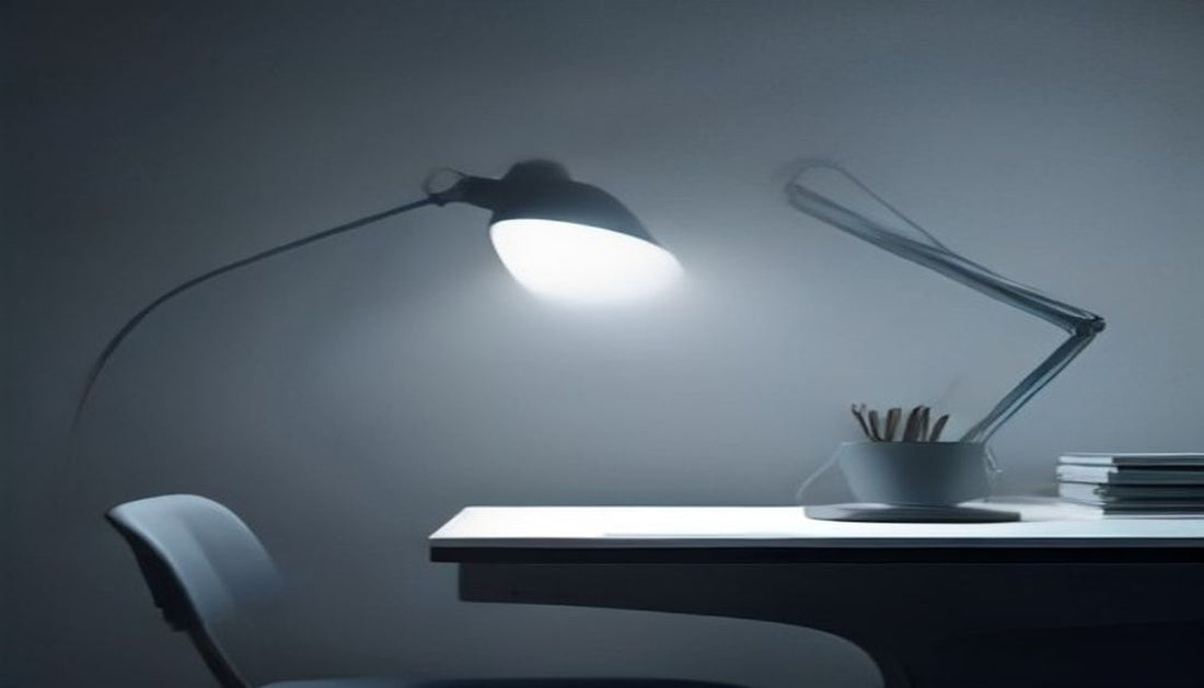 An adjustable desk lamp casting a single pool of soft light onto a minimal desk in a cool, dim blue-grey room.